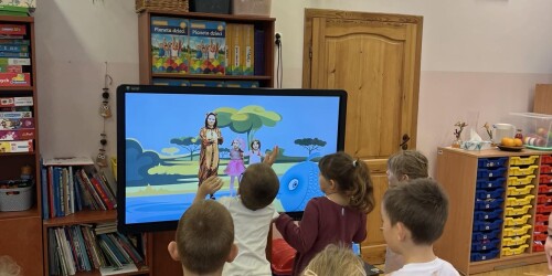 dzieci wykonują ćwiczenia prezentowane przez postacie zwierząt na tablicy interaktywnej